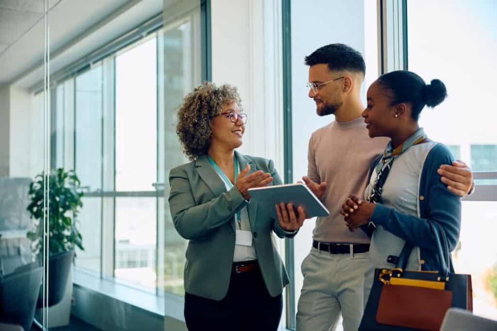 A woman explaining to a young couple how to verify insurance coverage
