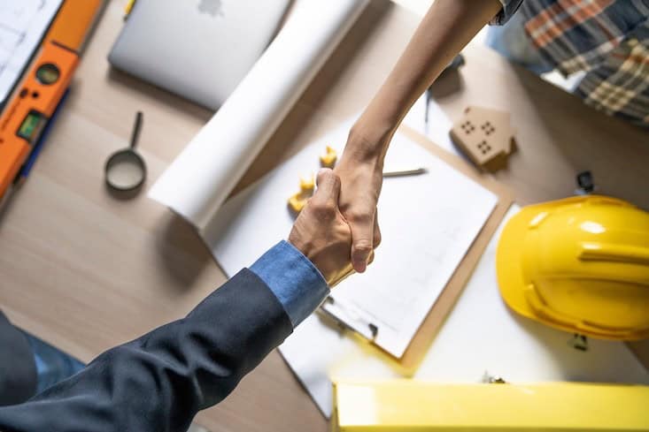 Owner of home shaking hands after architect build home finish.Architect or civil engineer concept.