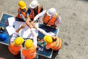 Ethnic diversity worker people, Success teamwork. Group of professional engineering people wearing hardhat safety helmet meeting with solar photovoltaic panels discussion in new project